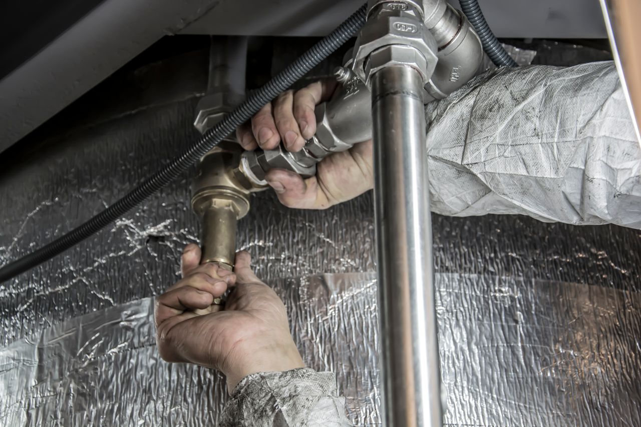 Offerings Close-up of a plumbers hands installing steel pipes indoors, showcasing skilled manual work.